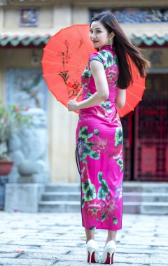 Ho Chi Minh Şehri, Vietnam - 3 Ağustos 2019: Vietnam 'da Ho Chi Minh City, Vietnam' da güzel bir sabah tapınağında büyüleyici bir şekilde poz veren Vietnamlı geleneksel Cheongsam giyim kızı