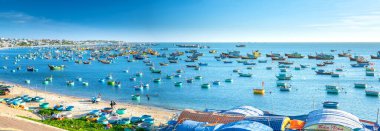 Mui Ne, Vietnam - 3 Mart 2020: Balıkçı köyü ve geleneksel balıkçı teknesi güneşli bir sabahta demir attı. Burası tekneler için körfez. Mui Ne, Vietnam 'da yağmur mevsimi fırtınalarından korunmak için.