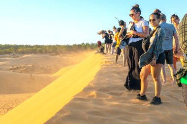 Mui Ne, Vietnam - 3 Mart 2020: Yabancı turistler yazın Mui Ne, Vietnam 'da çölün tepesinde günbatımını izlemek için yüksek altın tepeyi deneyimliyorlar