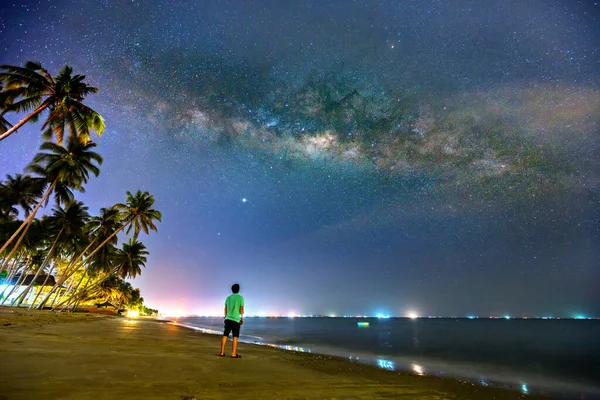 Silhouette of man watching the night sky in beautiful bay