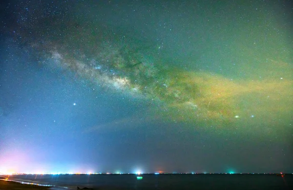 Midnight sea landscape with coconut palm tree Silhouette and Milky Way in the sky on a beautiful summer night. Long exposure photograph.