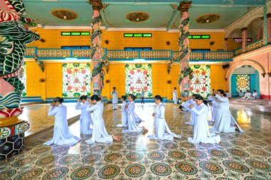 Tay Ninh, Vietnam - 9 Şubat 2020: insanlar kutsal Cao Dai manastırında dua ediyorlar. Cao Dai, Tay Ninh, Vietnam 'da farklı dinleri karıştıran bir Vietnam dinidir.