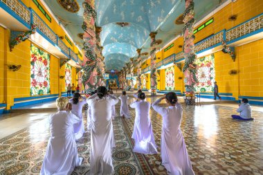 Tay Ninh, Vietnam - 9 Şubat 2020: insanlar kutsal Cao Dai manastırında dua ediyorlar. Cao Dai, Tay Ninh, Vietnam 'da farklı dinleri karıştıran bir Vietnam dinidir.