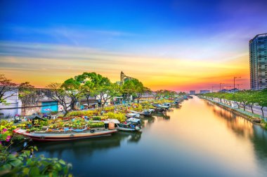Ho Chi Minh Şehri, Vietnam - 19 Ocak 2020: Çiçek dolu tekneler günbatımında kanal iskelesi boyunca park edilmiş, Ho Chi Minh City, Vietnam 'da yeni yıl için çiçek pazarı ticareti yapılan bir yer