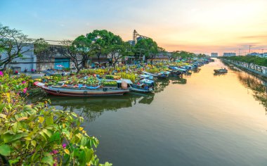 Ho Chi Minh Şehri, Vietnam - 19 Ocak 2020: Çiçek dolu tekneler günbatımında kanal iskelesi boyunca park edilmiş, Ho Chi Minh City, Vietnam 'da yeni yıl için çiçek pazarı ticareti yapılan bir yer
