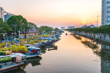 Ho Chi Minh Şehri, Vietnam - 19 Ocak 2020: Çiçek dolu tekneler günbatımında kanal iskelesi boyunca park edilmiş, Ho Chi Minh City, Vietnam 'da yeni yıl için çiçek pazarı ticareti yapılan bir yer
