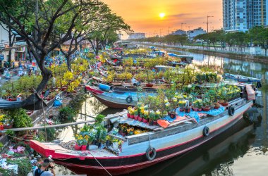 Ho Chi Minh City, Vietnam - 19 Ocak 2020: Kanal iskelesi boyunca gün batımı tekne iskelesi çiçek pazarı. Burası çiftçilerin kayısı ve diğer çiçekleri sattığı yer Ho Chi Minh şehrinde yeni yılda, Vietnam 'da.
