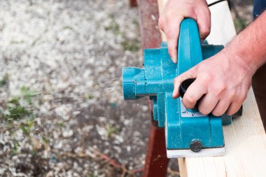 El ile elektrikli planya ahşap tahta üzerinde çalışma marangoz kapatın