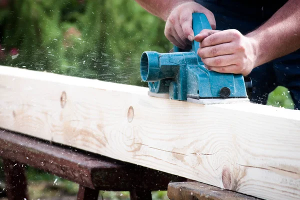 El ile elektrikli planya ahşap tahta üzerinde çalışma marangoz kapatın