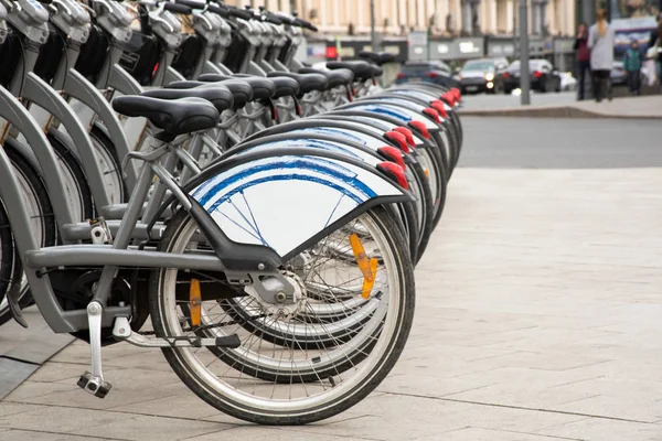 Ряд велосипедных колес в городе тротуар — стоковое фото