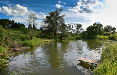Sakin bir nehir yaz aylarında iskelede. Ahşap iskele Köprüsü sabahları. Nehirde balık tutma yeri.