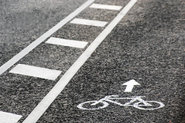Велосипедный белый знак или икона на асфальтированной дороге в городе — стоковое фото