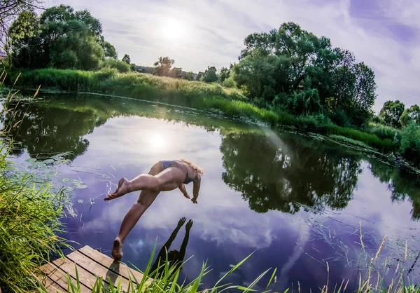 Menina mergulho da ponte na água — Fotografia de Stock