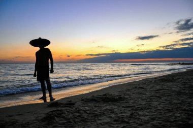 adam siluet batımında denize yakın