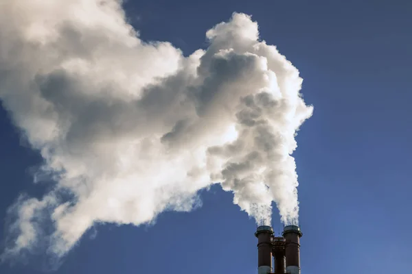 Rook coming out van pijpen in de heldere blauwe hemel, ecologie problemen — Stockfoto