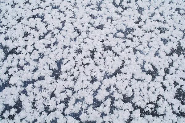 White snowflakes on blue ice — Stock Photo, Image