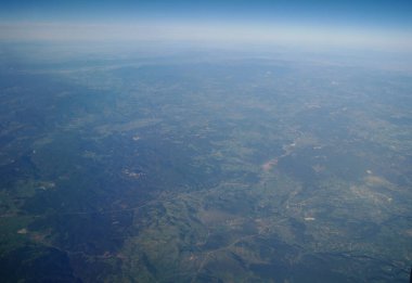 Uçak penceresinden bulutlara ve yeryüzüne bak.