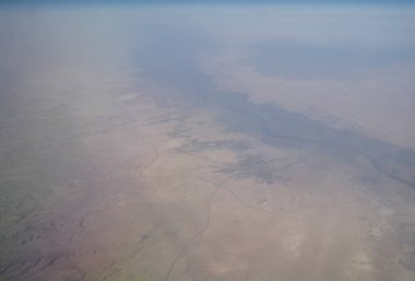 Uçak penceresinden bulutlara ve yeryüzüne bak.