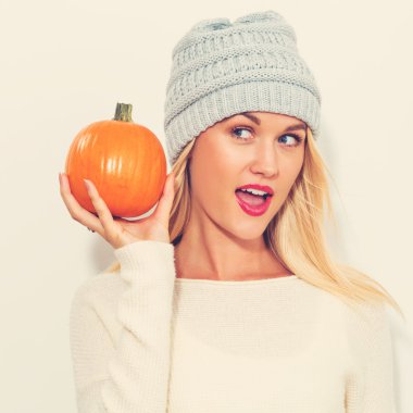 Balkabağı tutan genç bir kadın