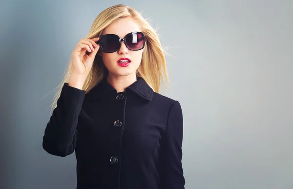 Blonde vrouw in zwarte jas — Stockfoto