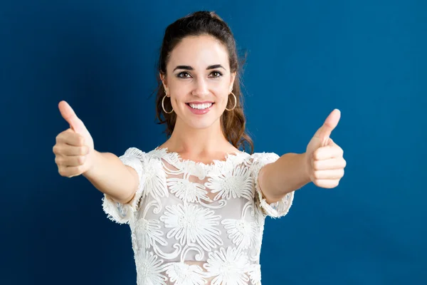 Young woman giving thumbs up — Stock Photo, Image