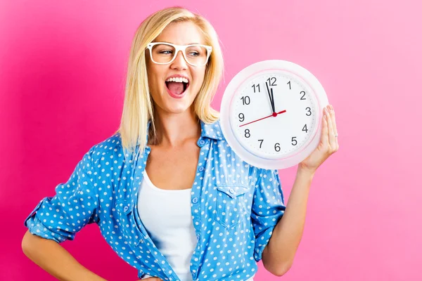 Mujer sosteniendo reloj mostrando casi doce — Foto de Stock