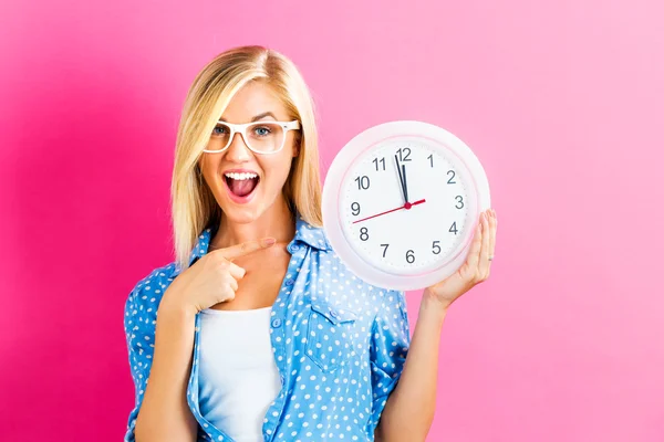 Mujer sosteniendo reloj mostrando casi doce — Foto de Stock