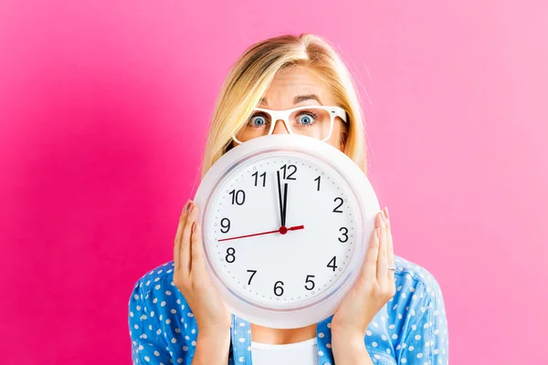 Mujer sosteniendo reloj mostrando casi doce — Foto de Stock