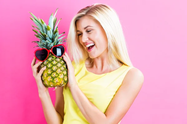 Woman holding pineapple with sunglasses — Stock Photo, Image
