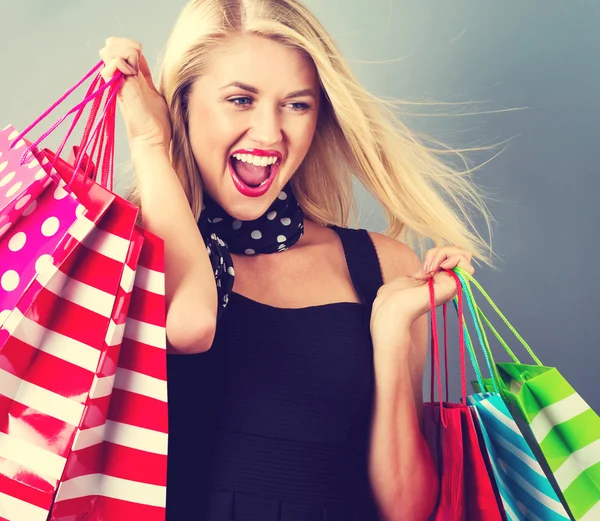 Jovem segurando sacos de compras — Fotografia de Stock