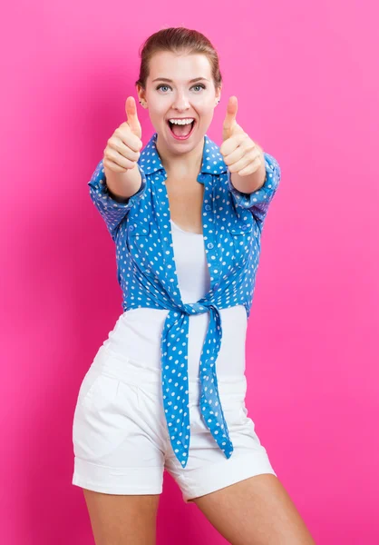 Счастливая молодая женщина показывает большие пальцы вверх — стоковое фото