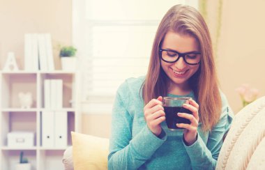 Mutlu genç bayan kahve içiyor.