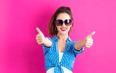 Happy young woman giving thumbs up clipart
