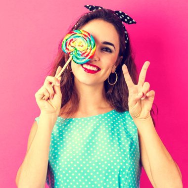 Genç bir kadın lolipop yiyor.