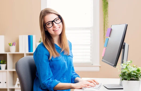 Щаслива молода жінка працює в своєму домашньому офісі — стокове фото