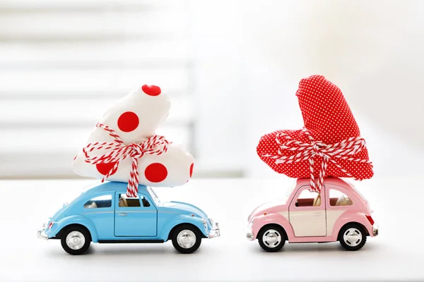 Miniature cars carrying heart cushion — Stock Photo, Image