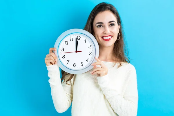 Mujer sosteniendo reloj mostrando casi 12 — Foto de Stock