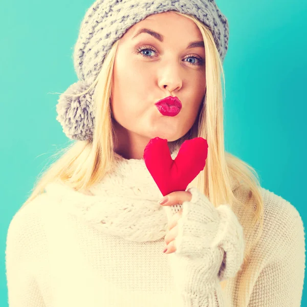 Bir kalp yastık tutan mutlu genç kadın — Stok fotoğraf