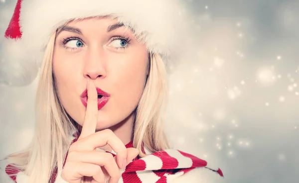 Woman with Santa hat making quiet gesture — Stock Photo, Image