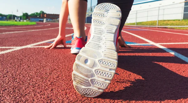 Female athlete on the starting line of a stadium track — Stock Photo, Image