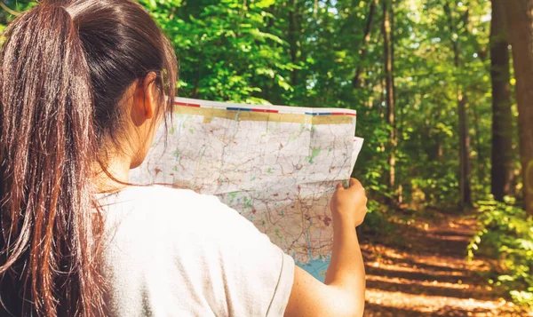 Mujer leyendo un mapa en el bosque — Foto de Stock