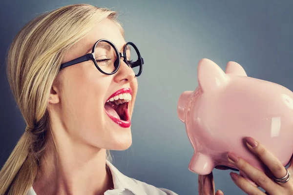 Jonge blonde vrouw met een piggy bank — Stockfoto