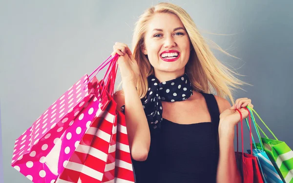 Happy young blonde woman with shopping bags — Stock Photo, Image