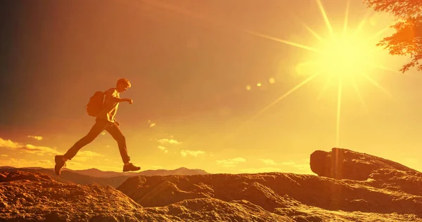 Mann springt bei Bergwanderung über Spalte — Stockfoto