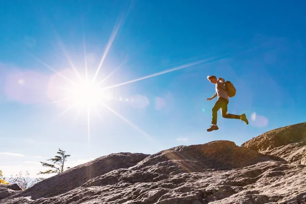 Hombre saltando sobre la brecha en la caminata de montaña — Foto de Stock