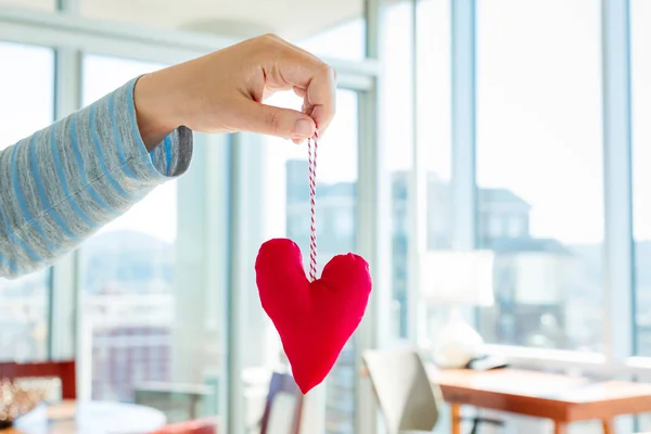 Mujer sosteniendo un cojín de corazón —  Fotos de Stock