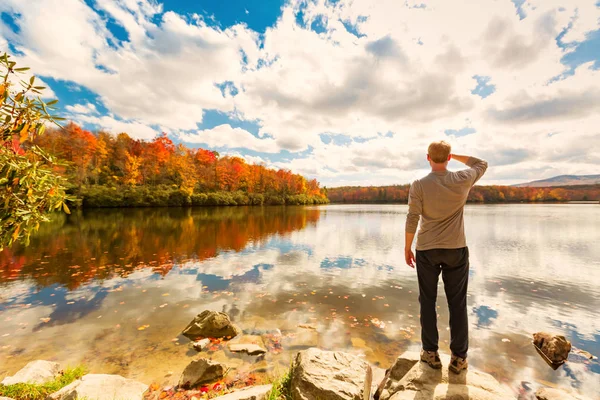 Uomo in piedi sul bordo di un lago — Foto Stock