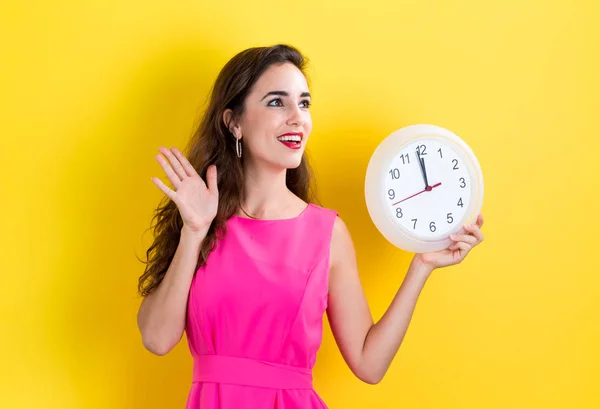 Woman holding clock showing nearly 12 — Stock Photo, Image