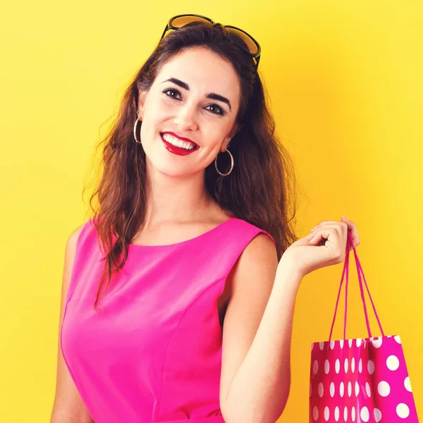 Happy young woman holding a shopping bag — Stock Photo, Image