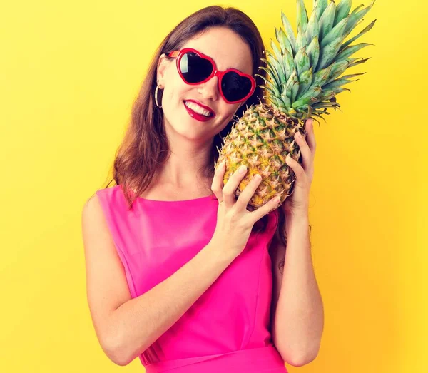 Šťastná mladá žena držící ananas — Stock fotografie
